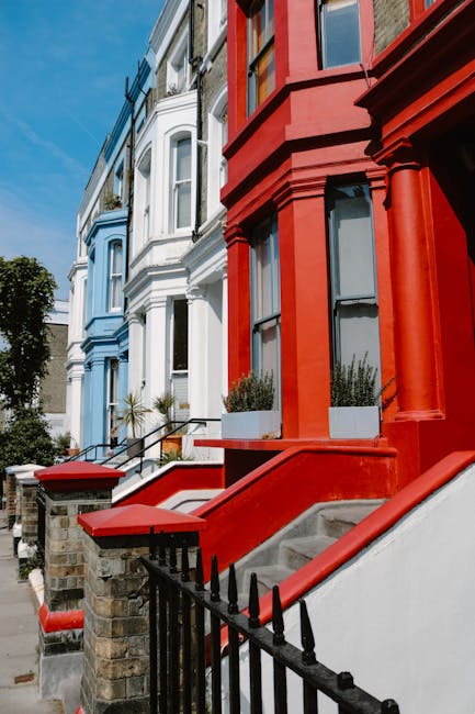 Close-up view of the exterior facades of residential buildings in Bermondsey, featuring a row of Victorian-style terraced houses with ornate architectural details. The buildings are painted in vibrant